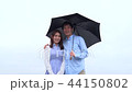 Couple umbrella looking at camera Couple umbrella looking at camera 44150802