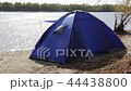 A lonely blue tent blown up by a strong wind on the Bank of an autumn river 44438800