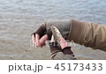 A bum caught a small fish by the bait, but it unexpectedly slips out of its hands. 45173433