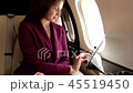 beautiful young woman sits in a plane and works on laptop 45519450
