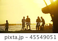 Relaxing tourists standing, smiling and talking on seashore at sunset in slo-mo 45549051