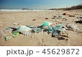 Grubby sandy sea shore full of plastic litter and shells on sunny day in spring 45629872