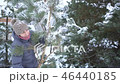 Attractive woman carrying large branch of pine with snow in her winter garden for Merry Christmas 46440185