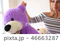Pretty young woman holding with big teddy bear 46663287