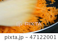 Stirring grated carrots while frying in the pan 47122001