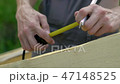 the worker makes measurements with a tape measure 47148525
