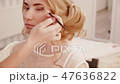 Stylist makes eyes makeup to the blonde bride girl 47636822