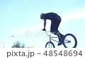 Cyclist performs a jump on the springboard in the skate park 48548694