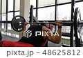 Young muscular man on bench press. Guy trains in the gym with a barbell 48625812