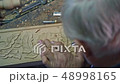 Wood carver is carving leaves and flowers. 48998165
