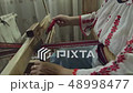 Weaver who is weaving a traditional belt. 48998477