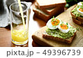 Orange juice pouring into glass on wooden table 49396739