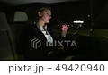 Tired businesswoman in the car talking on the phone. She rides in the car on the night road. 49420940