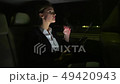 Tired businesswoman in the car talking on the phone. She rides in the car on the night road. 49420943