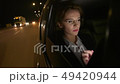 Businesswoman in the car uses a tablet for work. She rides in the car on the night road. 49420944