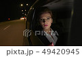 Businesswoman in the car uses a tablet for work. She rides in the car on the night road. 49420945
