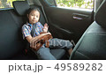 happy little girl wearing seatbelts in car 49589282