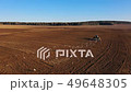 Tractor plows and makes seeding and sowing crops. 49648305