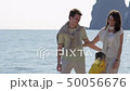 Happy parents and the daughter walk on the coast in the sunny day 50056676