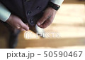 FullHD Stylish man in a suit fastening buttons on his jacket preparing to go out 50590467