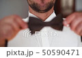 FullHD Wearing bow tie close up. Male hands check correct and adjust casual bow tie 50590471
