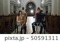 Couple musicians is playing bandura and accordion in catholic church 50591311