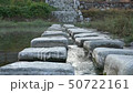 Stepping on a stream in front of a quiet rural village 50722161