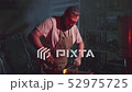 A blacksmith is working in a blacksmith shop 52975725