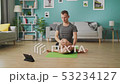 A young man studies yoga using instructions on a tablet 53234127