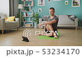 A young man studies yoga using instructions on a tablet 53234170