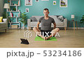 Young man following the instructions on the tablet and do the asana 53234186
