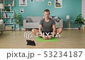 Young man following the instructions on the tablet and do the asana 53234187