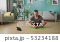 Young man following the instructions on the tablet and do the asana 53234188
