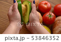Woman opening an avocado in two parts 53846352
