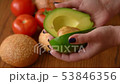 Woman opening an avocado in two parts 53846356