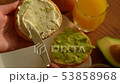 Woman spreading creamy cheese on avocado toast 53858968