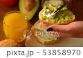Woman spreading creamy cheese on avocado toast 53858970