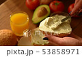 Woman spreading creamy cheese on avocado toast 53858971