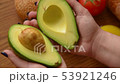 Woman opening an avocado in two parts 53921246