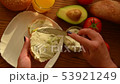 Woman spreading creamy cheese on avocado toast 53921249