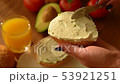 Woman spreading creamy cheese on avocado toast 53921251