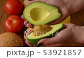 Woman opening an avocado in two parts 53921857