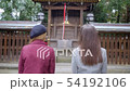International women praying at Japanese shrine. 54192106