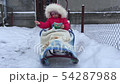 Baby girl is sitting on a sleigh 54287988