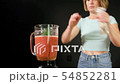 A young woman is cooking raw gazpacho. She adds spices in a blender 54852281