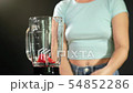 A young woman puts tomatoes in to the blender and add some water. Close up 54852286