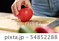 A young woman cuts a ripe tomato. Close up 54852288