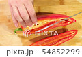 Young woman slicing red bell pepper. 54852299