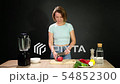 A young woman is cooking raw gazpacho. 54852300