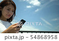 Up of woman operating smartphone under blue sky (right copy space) 54868958